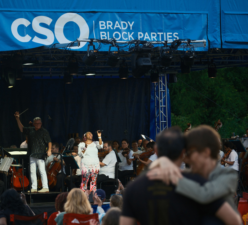 John Morris Russell conducting the CSO at the Evanston Brady Block Party,  with vocalist Ciara Harper, July 2023. Credit: JP Leong