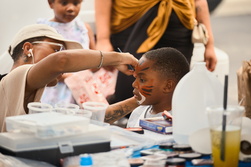 Children enjoying getting their faces painted at the Bond Hill Brady Block Party, July 2023. Credit: JP Leong