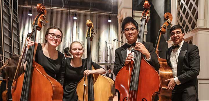4 student bassists smile for the camera
