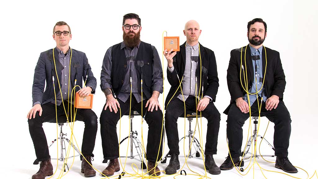 Four musicians from ensemble Sō Percussion pose with instruments and wires